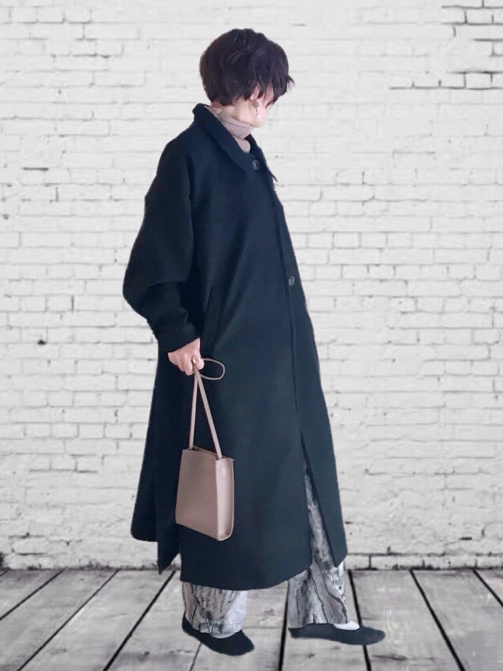 ブラック系のその他アウター、ブラック系のその他パンツ、ベージュ系のベストを着用したレディースの秋コーディネートの2枚目の写真