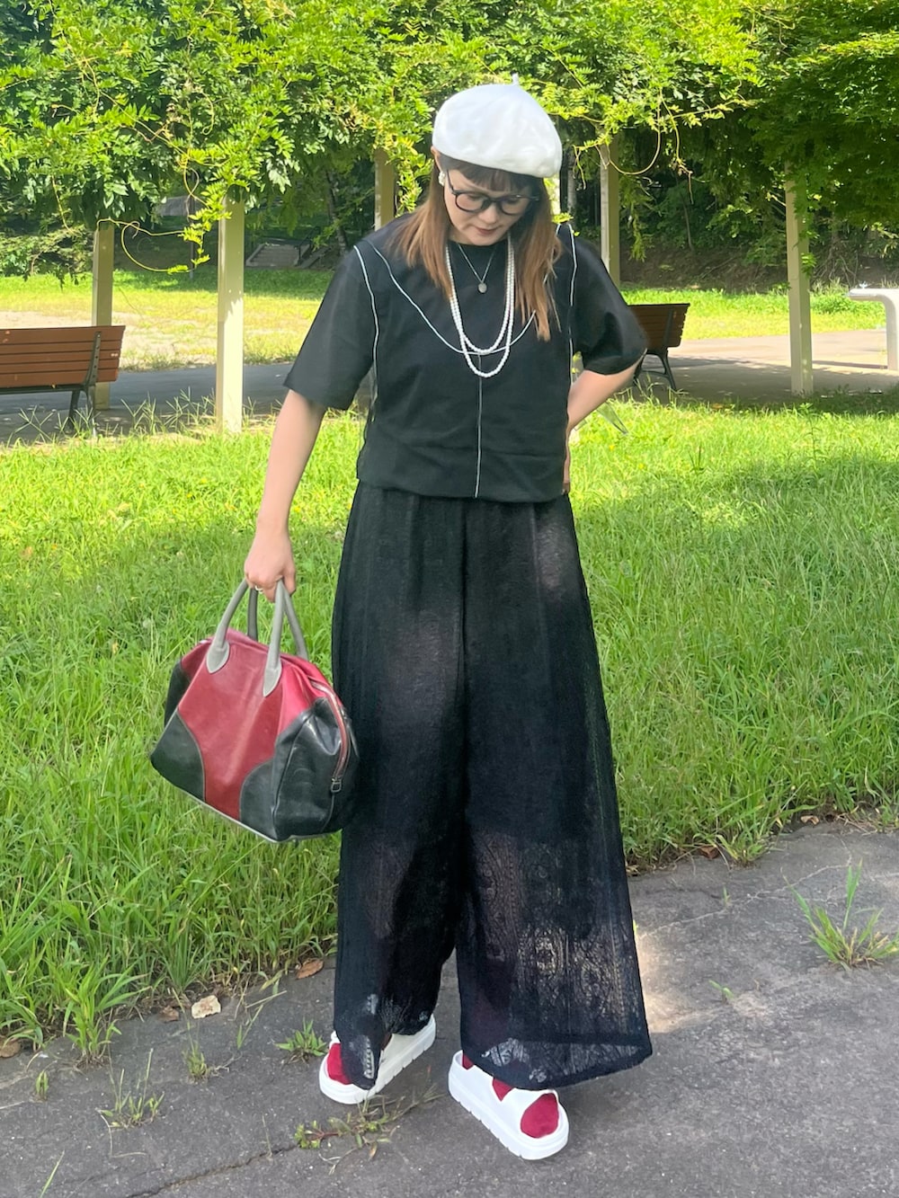 ブラック系のその他パンツ、ブラック系のTシャツ/カットソー、レッド系のトートバッグを着用したレディースの夏コーディネートの2枚目の写真