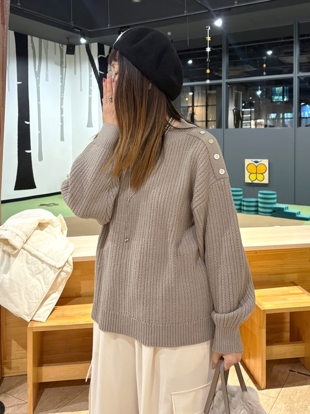 ブラウン系のニット/セーター、ホワイト系のその他パンツ、ベージュ系のショルダーバッグを着用したレディースの冬コーディネートの3枚目の写真