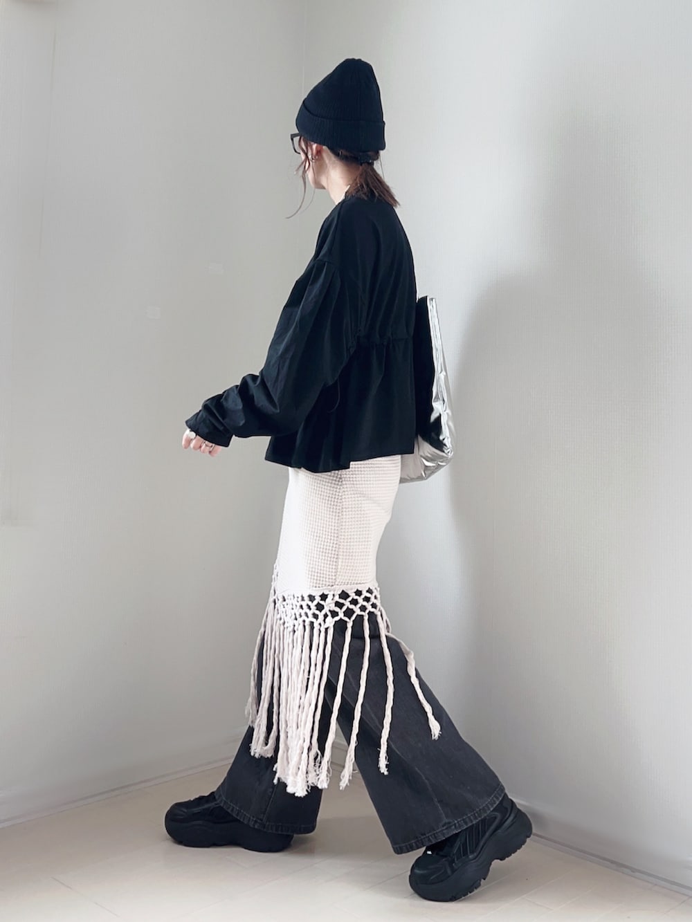 ブラック系のTシャツ/カットソー、ホワイト系のスカート、グレー系のデニムパンツを着用したレディースの春コーディネートの3枚目の写真