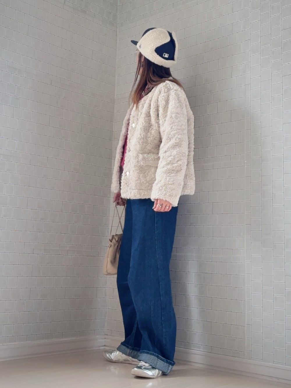 パープル系のスウェット、ベージュ系のノーカラーコート、ブルー系のデニムパンツを着用したレディースの秋コーディネートの3枚目の写真