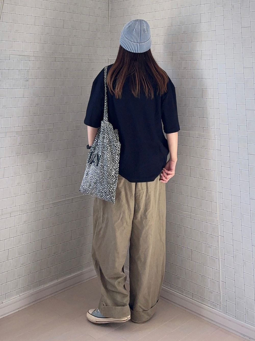 ベージュ系のその他パンツ、ブラック系のポロシャツ、ブラック系のトートバッグを着用したレディースの春コーディネートの3枚目の写真