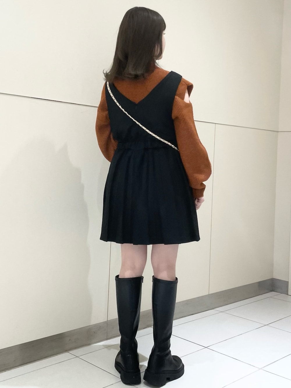 ブラック系のブーツ、ブラック系のワンピース、オレンジ系のニット/セーターを着用したレディースの秋コーディネートの4枚目の写真