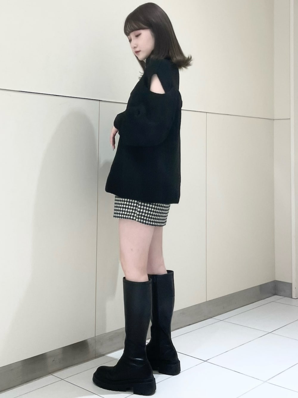 ブラック系のスカート、ブラック系のブーツ、ブラック系のニット/セーターを着用したレディースの秋コーディネートの3枚目の写真