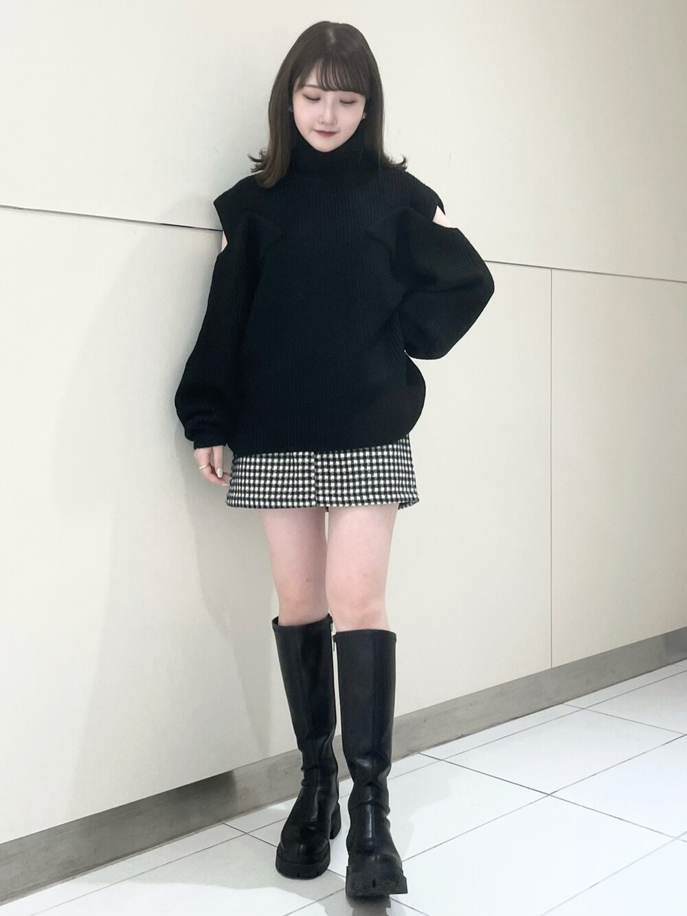 ブラック系のスカート、ブラック系のブーツ、ブラック系のニット/セーターを着用したレディースの秋コーディネートの5枚目の写真