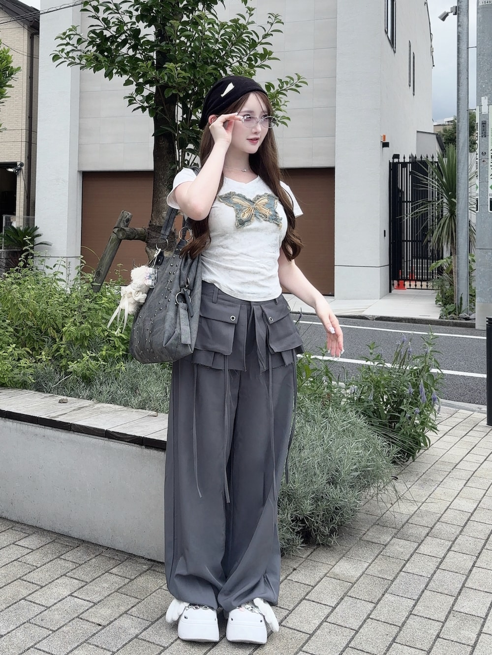 グレー系のスラックス、ホワイト系のトップス、ホワイト系のサングラスを着用したレディースの夏コーディネートの2枚目の写真