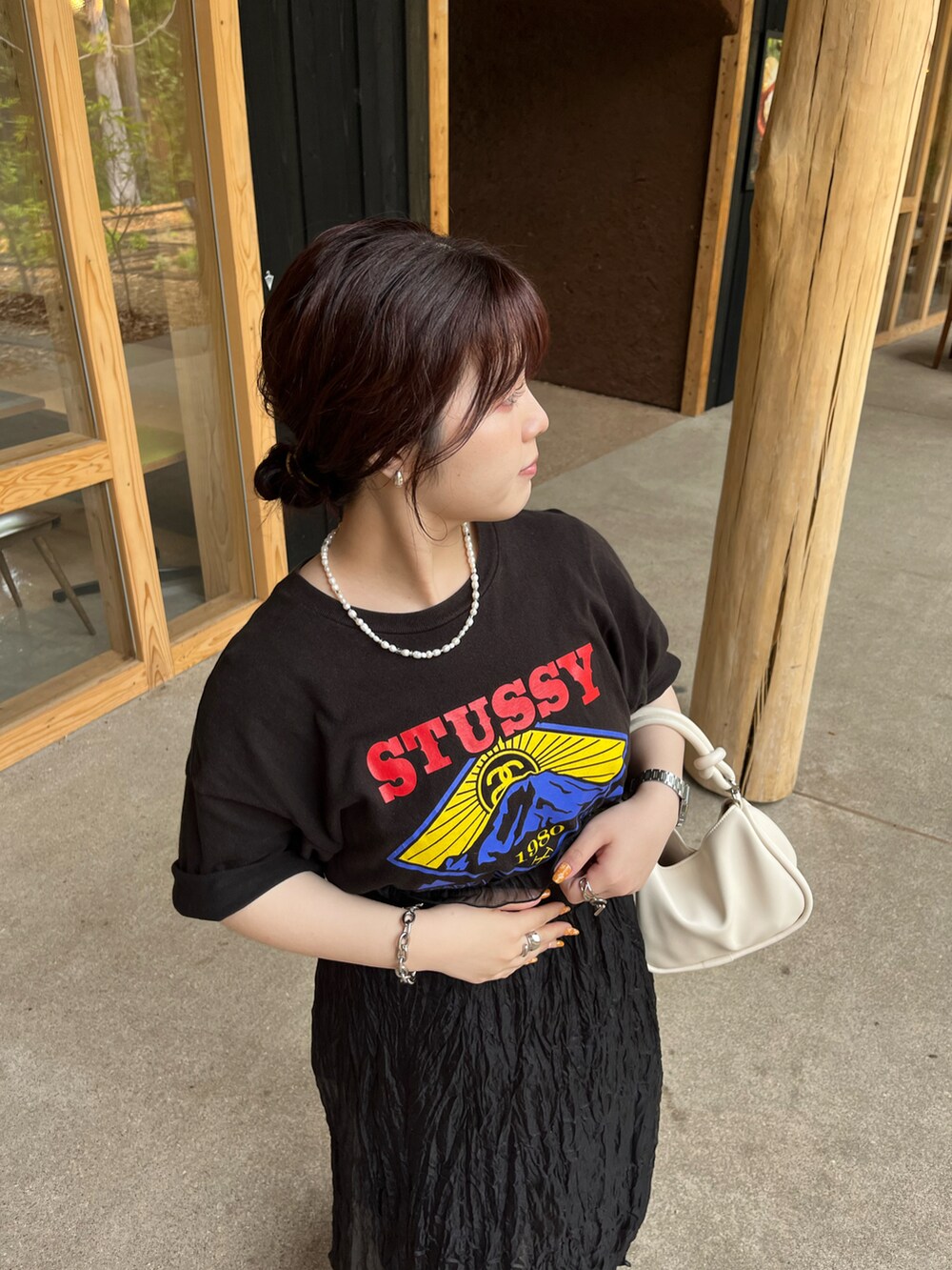 ブラック系のTシャツ/カットソー、ホワイト系のハンドバッグ、ブラック系のワンピースを着用したレディースの夏コーディネートの2枚目の写真