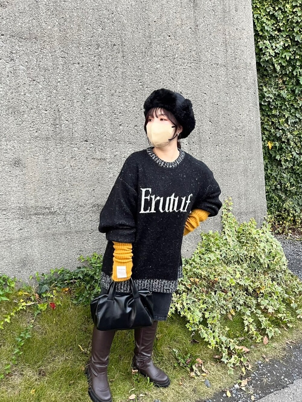 ブラック系のニット/セーター、ブラック系のボストンバッグ、グレー系のスカートを着用したレディースの夏コーディネートの2枚目の写真