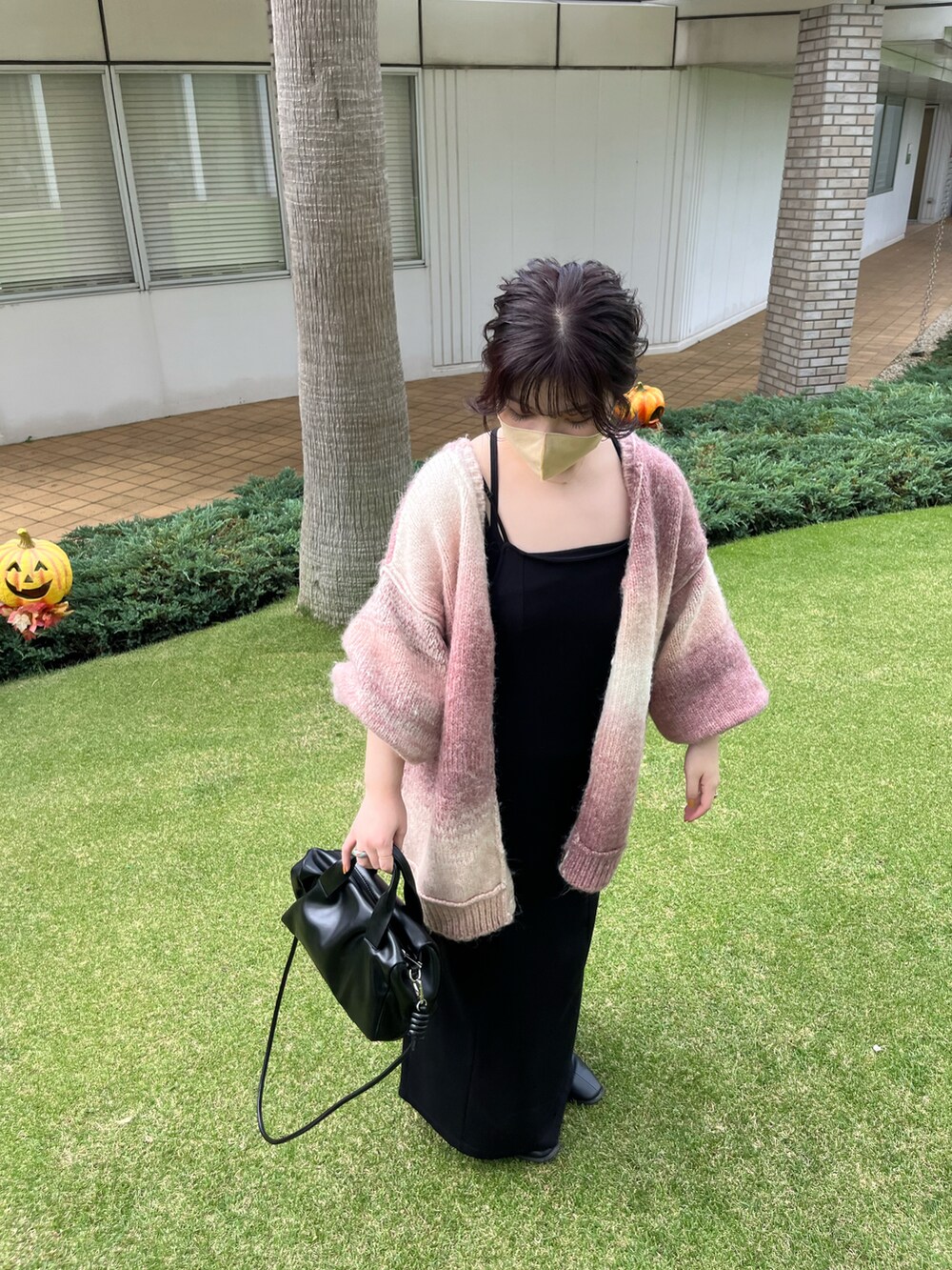 ピンク系のカーディガン/ボレロ、ブラック系のボストンバッグ、ブラック系のワンピースを着用したレディースの夏コーディネートの2枚目の写真