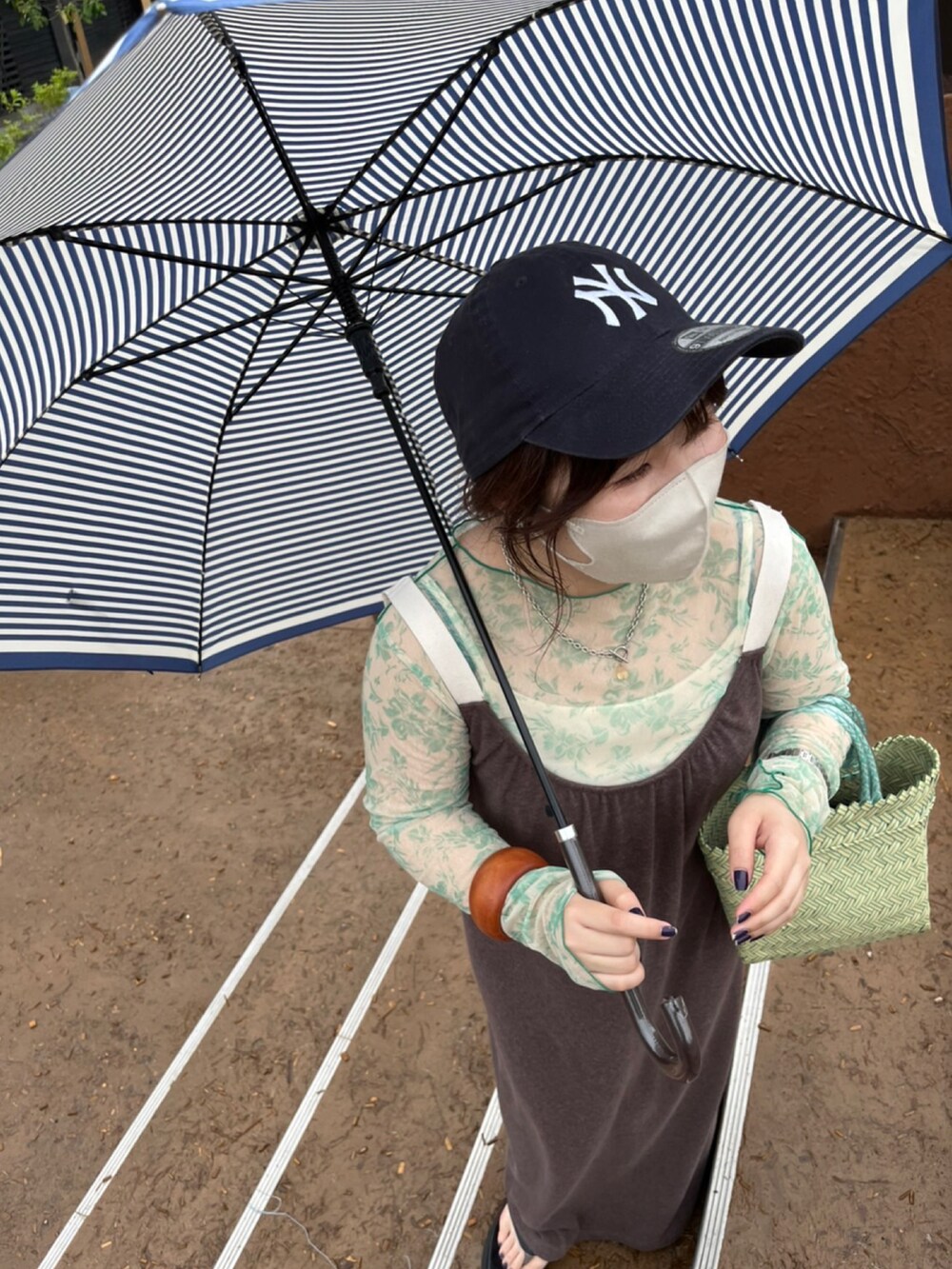 グリーン系のかごバッグ、ブラウン系のワンピース、グリーン系のTシャツ/カットソーを着用したレディースの夏コーディネートの2枚目の写真