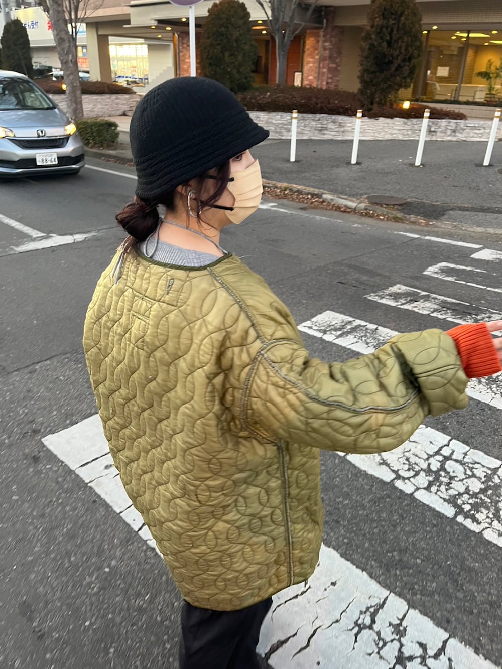 グリーン系のジャケット/アウター、グレー系のニット/セーター、ブラック系のワンピースを着用したレディースの夏コーディネートの2枚目の写真