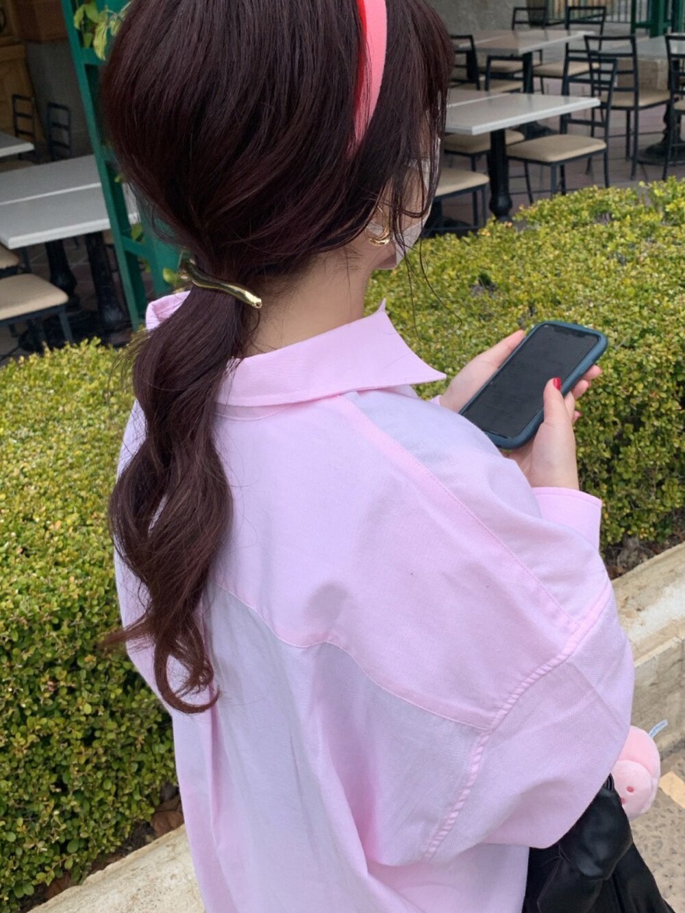 ブラック系のハンドバッグ、ピンク系のシャツ/ブラウス、ホワイト系のスカートを着用したレディースの夏コーディネートの2枚目の写真