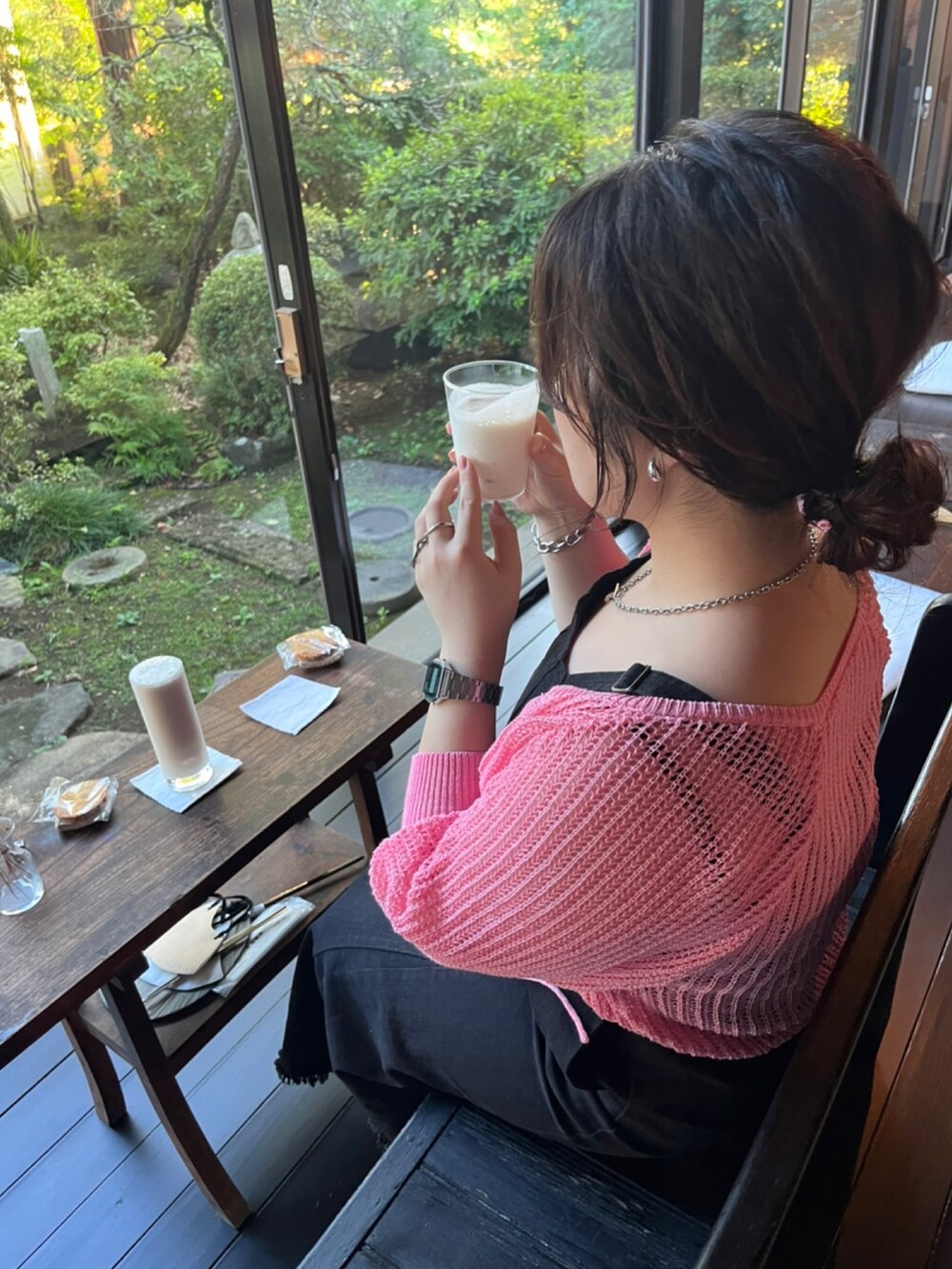 ブラック系のワンピース、ピンク系のカーディガン/ボレロ、シルバー系のデジタル腕時計を着用したレディースの夏コーディネートの2枚目の写真