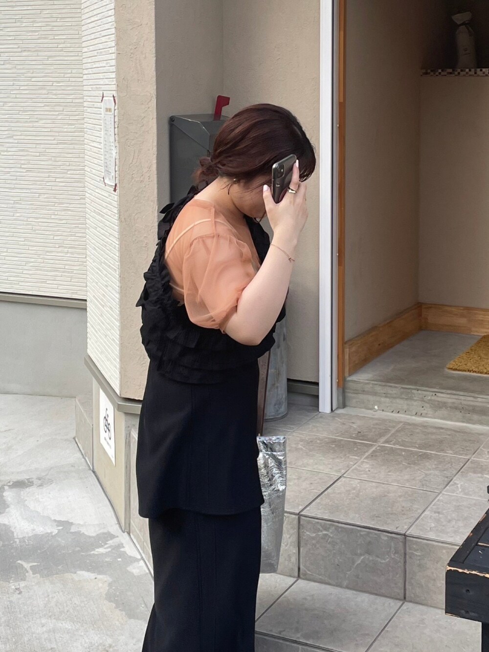 シルバー系のトートバッグ、ブラック系のパンプス、ブラック系のスカートを着用したレディースの夏コーディネートの3枚目の写真