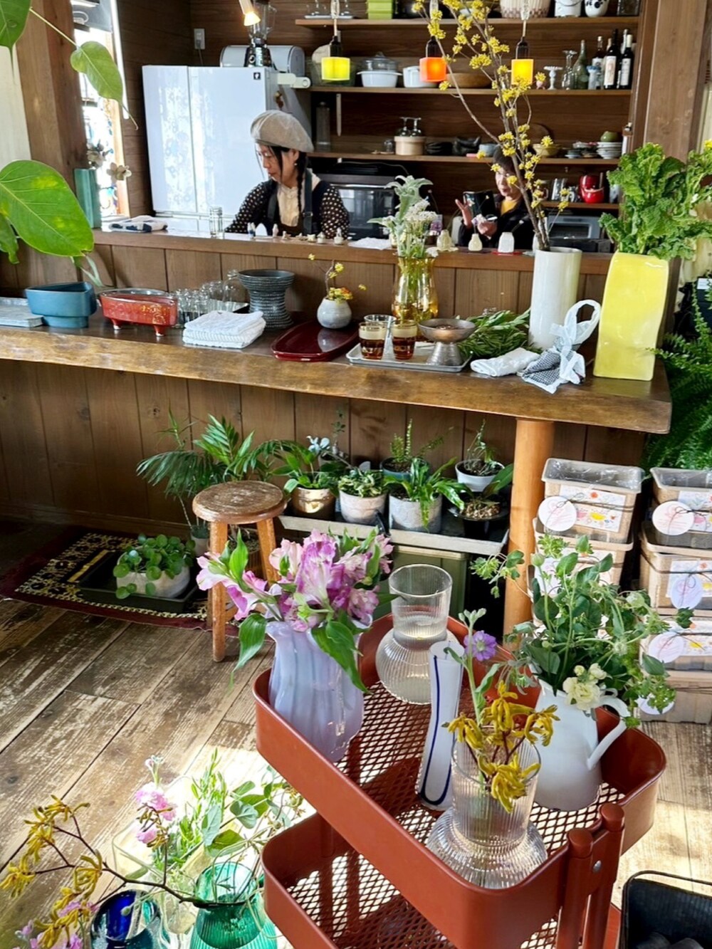 イエロー系のトップス、ブラック系のスカート、レッド系のブーツを着用したレディースの春コーディネートの2枚目の写真