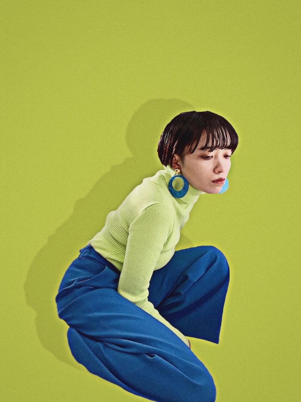 イエロー系のその他アウター、ブラック系のパンプス、ブルー系のスラックスを着用したレディースの冬コーディネートの3枚目の写真