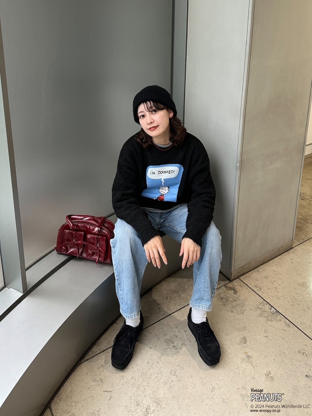 ブラック系のニット/セーター、レッド系のボストンバッグを着用したレディースの秋コーディネートの2枚目の写真