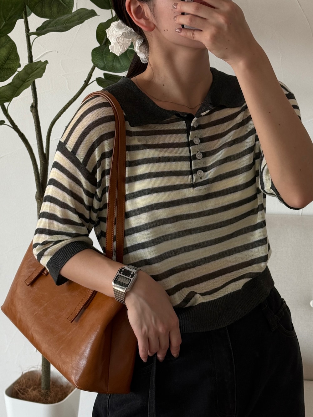 ブラック系のデニムパンツ、イエロー系のハンドバッグ、ブラック系のバレエシューズを着用したレディースの夏コーディネートの2枚目の写真