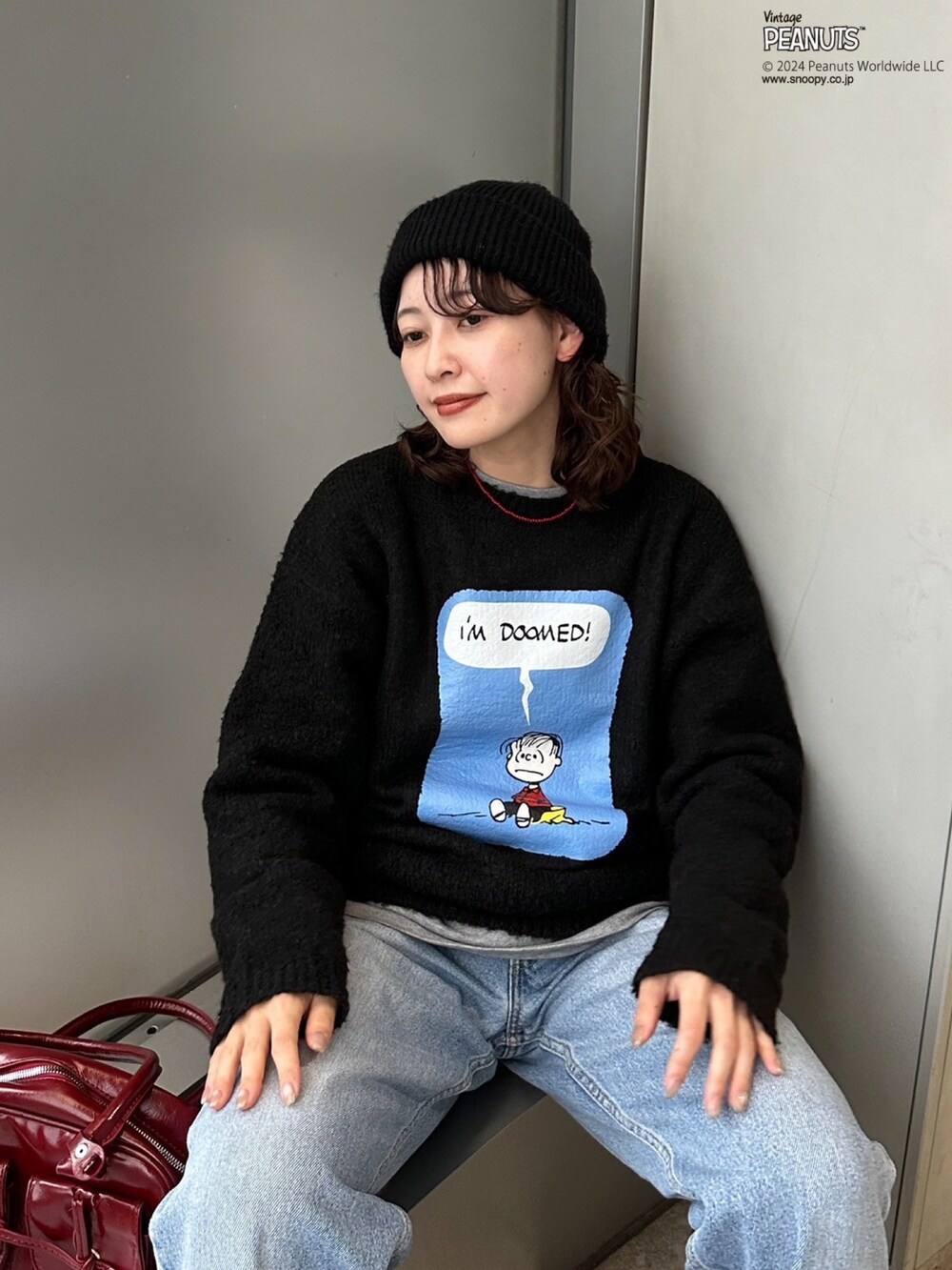 ブラック系のニット/セーター、レッド系のボストンバッグを着用したレディースの秋コーディネートの3枚目の写真