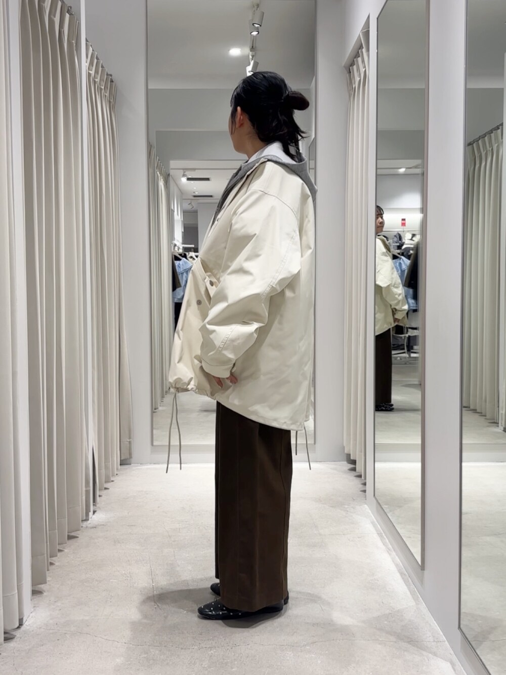 ホワイト系のミリタリージャケット、グレー系のパーカー、ブルー系のTシャツ/カットソーを着用したレディースの冬コーディネートの2枚目の写真