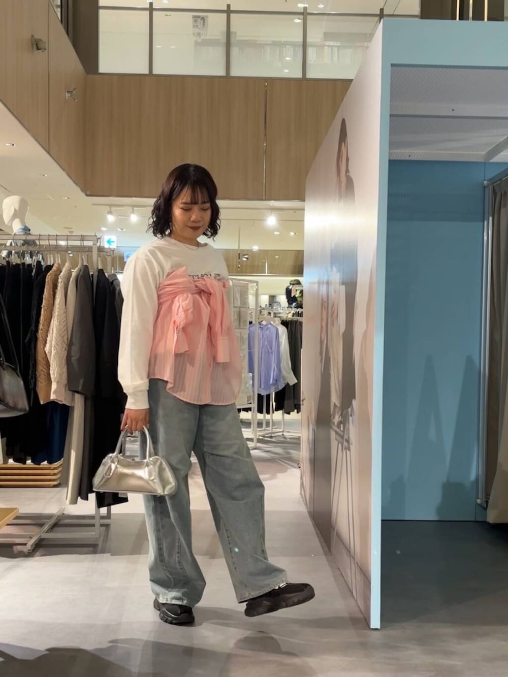 ブラック系のスニーカー、シルバー系のボストンバッグ、その他のTシャツ/カットソーを着用したレディースの春コーディネートの2枚目の写真