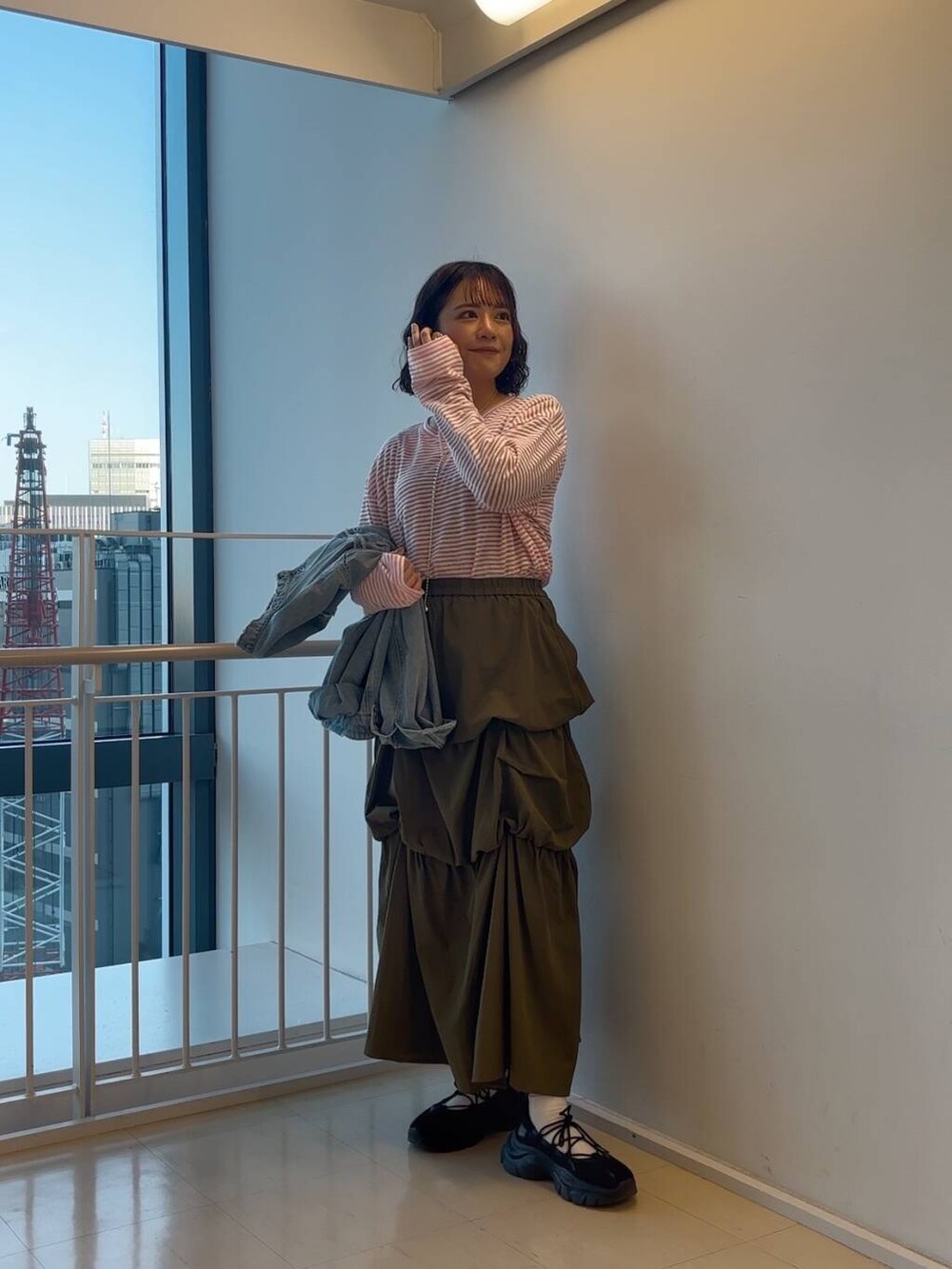 ブラック系のスニーカー、グリーン系のスカート、ピンク系のTシャツ/カットソーを着用したレディースの冬コーディネートの2枚目の写真