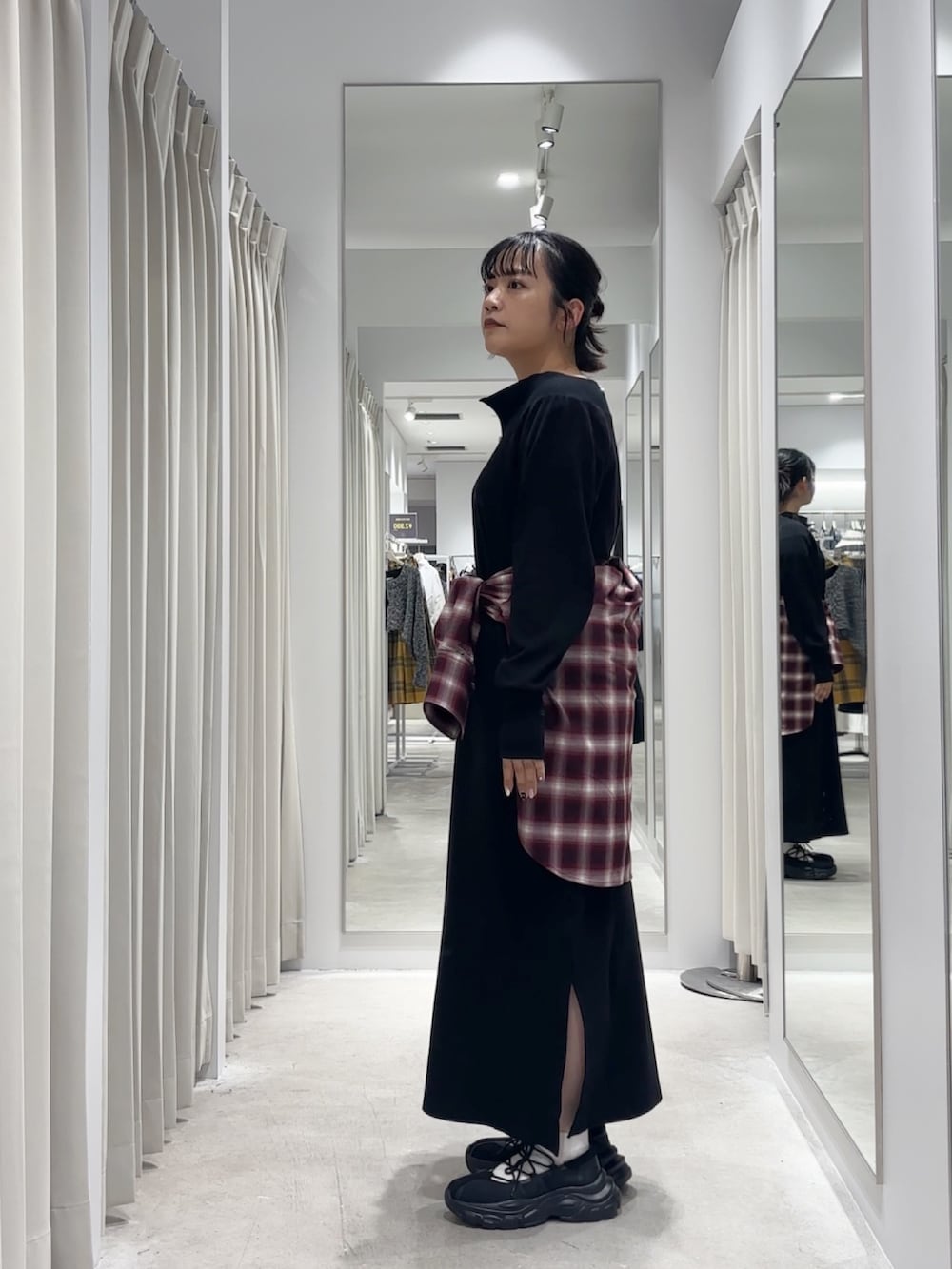 ブラック系のワンピース、レッド系のシャツ/ブラウス、ブラック系のスニーカーを着用したレディースの秋コーディネートの3枚目の写真