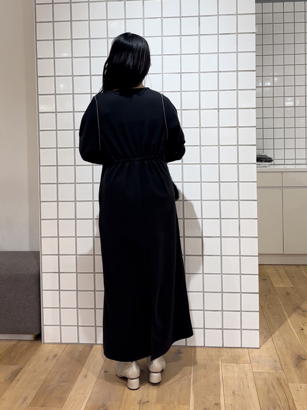 ゴールド系のブーツ、ブラック系のワンピース、グレー系のマフラーを着用したレディースの秋コーディネートの4枚目の写真
