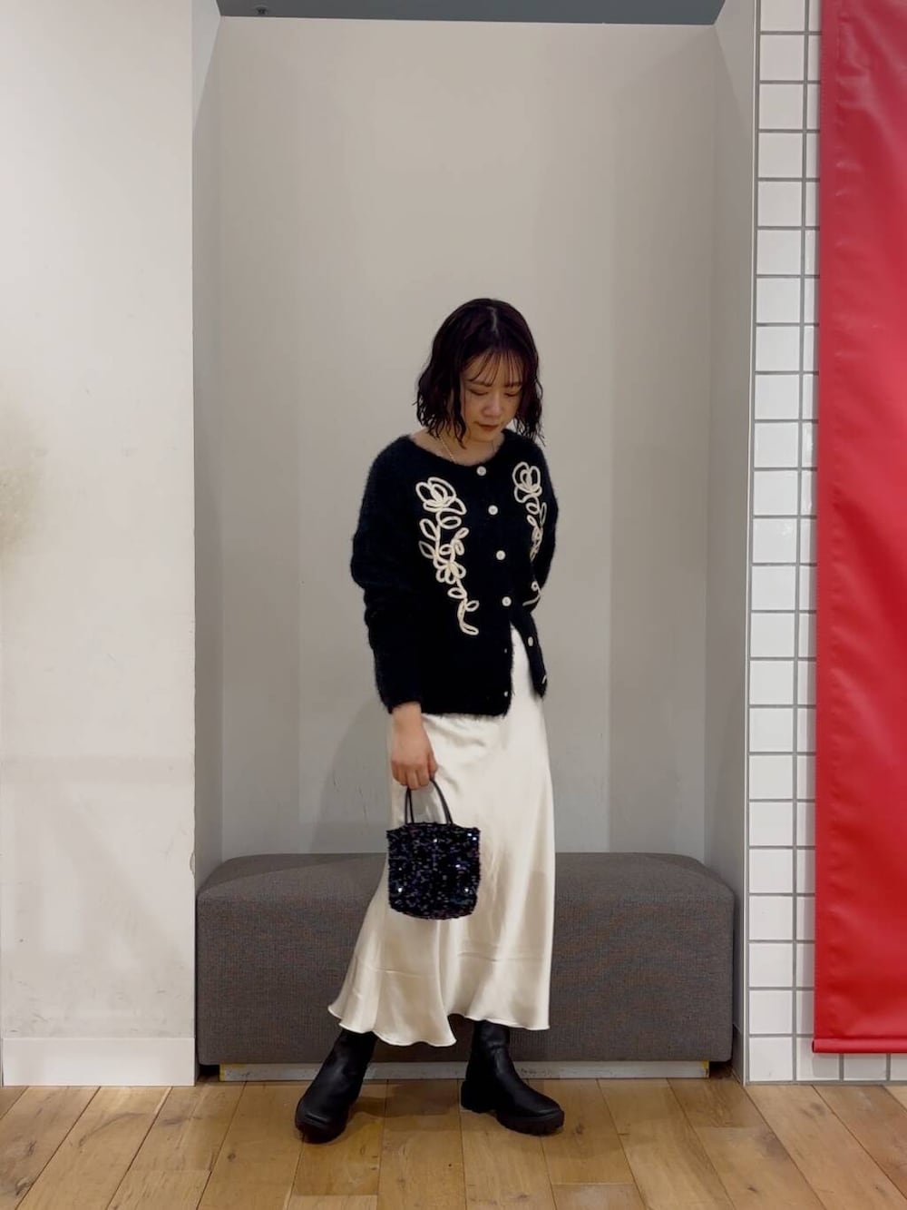 ブラック系のショルダーバッグ、ブラック系のブーツ、ブラック系のカーディガン/ボレロを着用したレディースの冬コーディネートの2枚目の写真