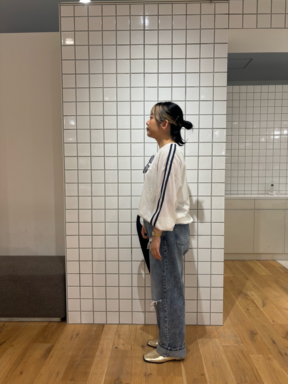 ブラック系のトートバッグ、ゴールド系のバレエシューズ、ホワイト系のタンクトップを着用したレディースの秋コーディネートの4枚目の写真