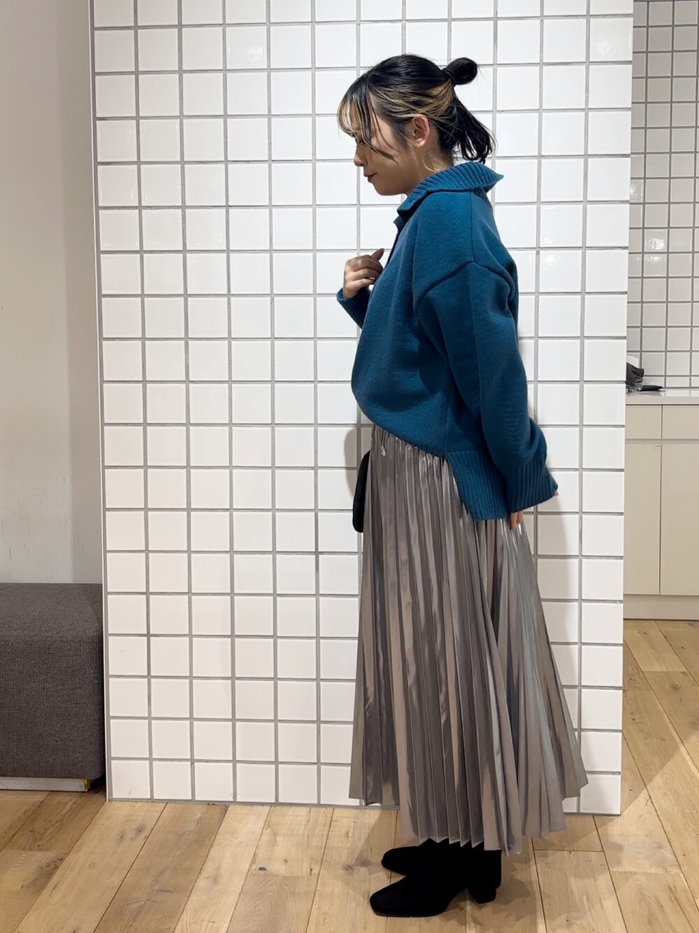 ブルー系のニット/セーター、シルバー系のスカート、ブラック系のショルダーバッグを着用したレディースの秋コーディネートの4枚目の写真