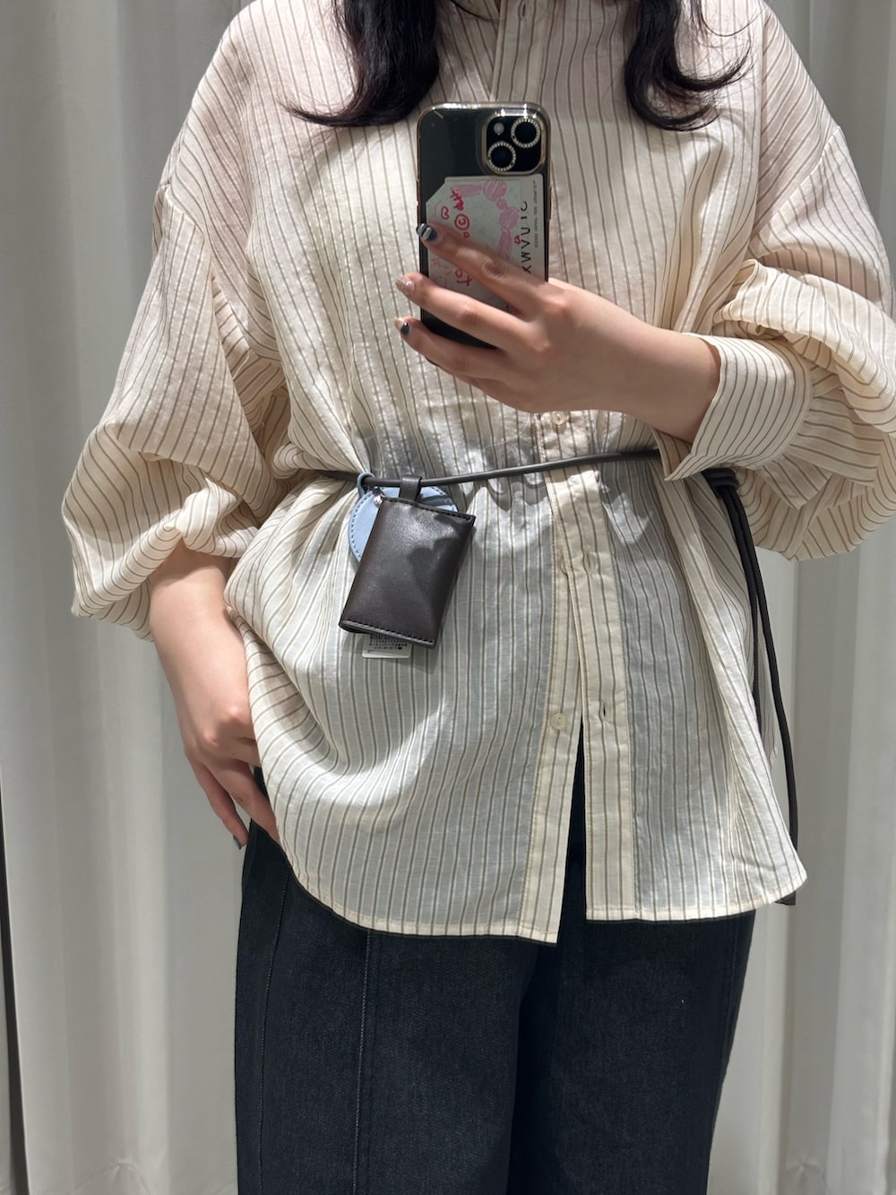 ホワイト系のキャミソール、ベージュ系のシャツ/ブラウス、ブルー系のデニムパンツを着用したレディースの春コーディネートの2枚目の写真