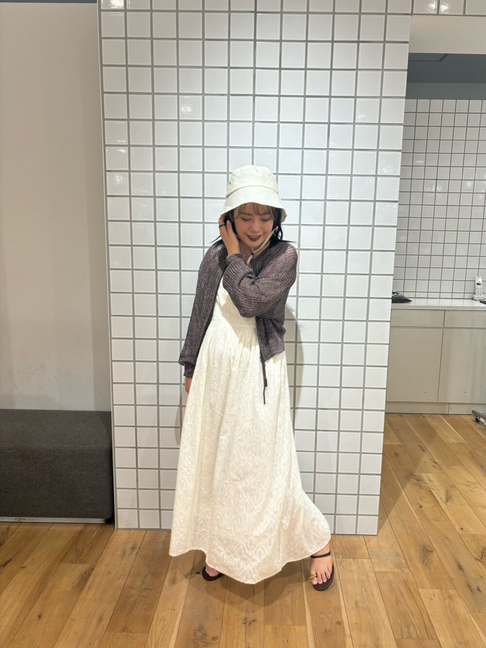 ブラウン系のカーディガン/ボレロ、ホワイト系のタンクトップ、ホワイト系のワンピースを着用したレディースの夏コーディネートの2枚目の写真