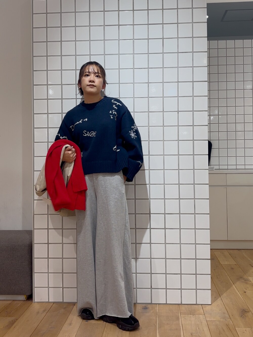 ホワイト系のその他アウター、ブルー系のニット/セーター、グレー系のスウェットパンツを着用したレディースの冬コーディネートの2枚目の写真