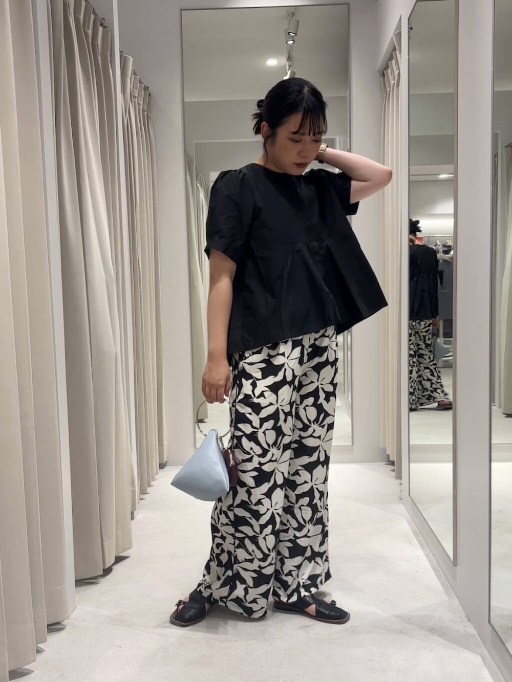 ブルー系のハンドバッグ、ブラック系のその他パンツ、ブラック系のシャツ/ブラウスを着用したレディースの夏コーディネートの2枚目の写真