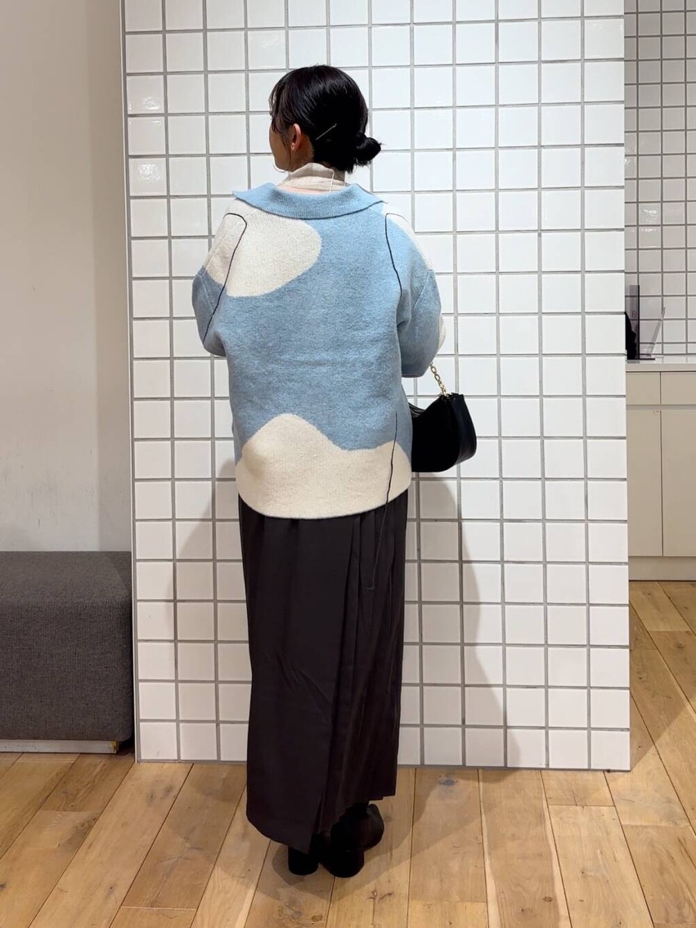 ベージュ系のTシャツ/カットソー、ブラック系のショルダーバッグ、ブラック系のブーツを着用したレディースの冬コーディネートの5枚目の写真