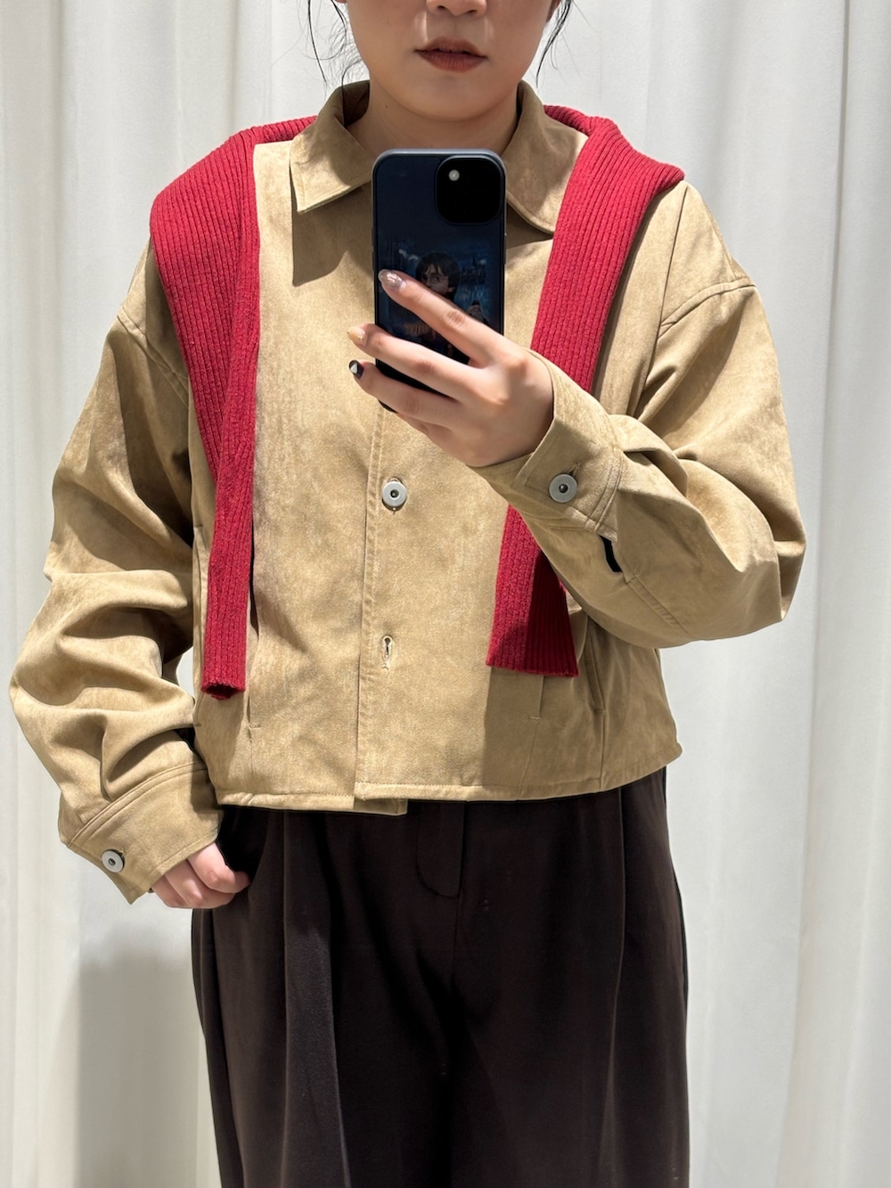 ベージュ系のその他アウター、レッド系のニット/セーター、ブラウン系のその他パンツを着用したレディースの秋コーディネートの2枚目の写真