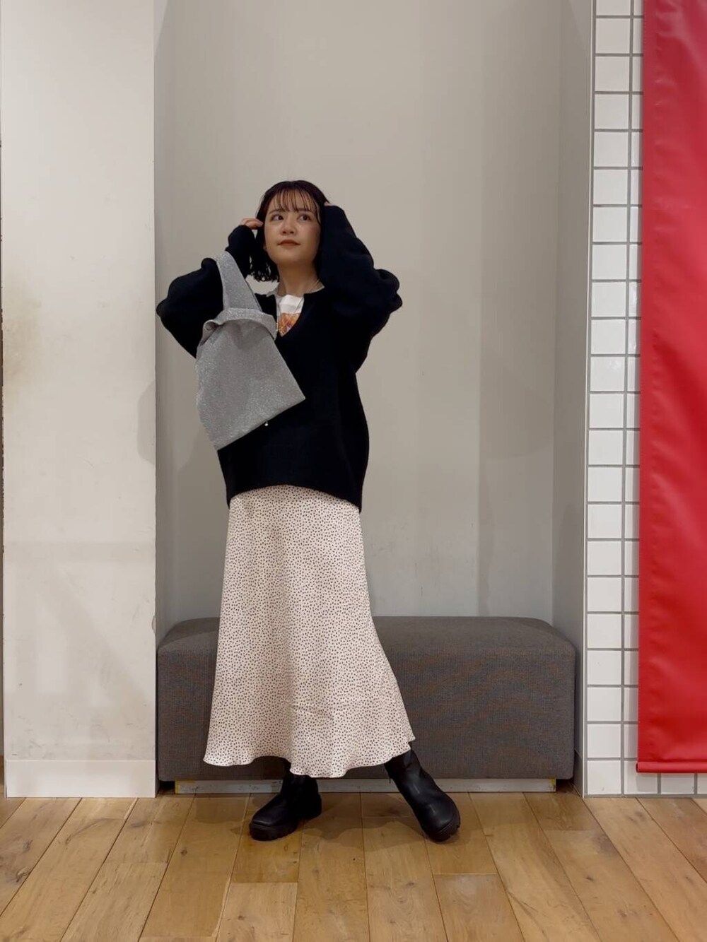 シルバー系のトートバッグ、ブラック系のブーツ、その他のTシャツ/カットソーを着用したレディースの冬コーディネートの2枚目の写真