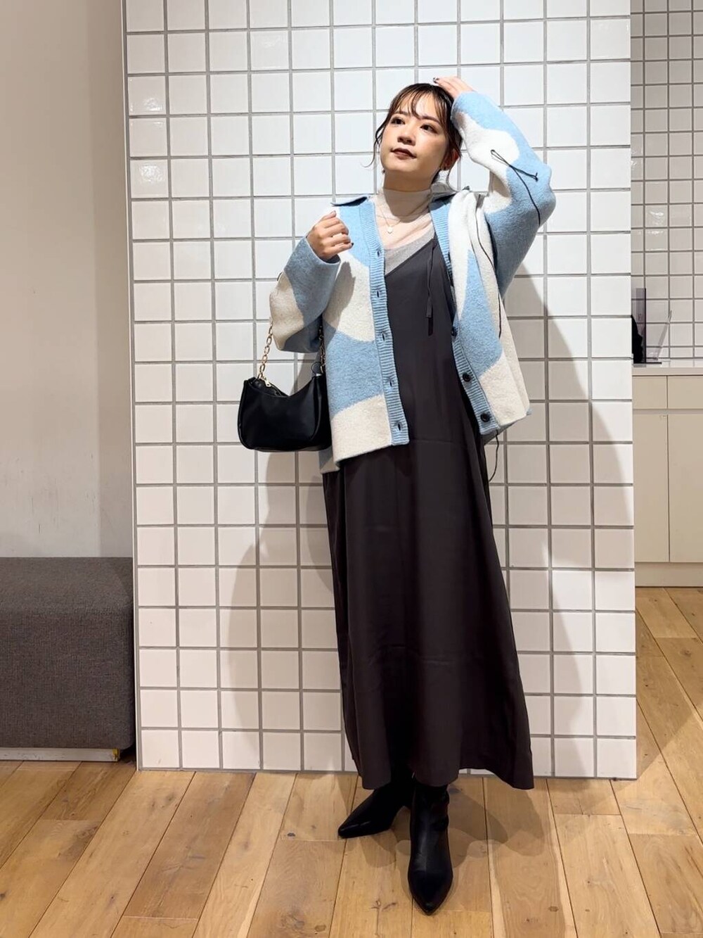 ベージュ系のTシャツ/カットソー、ブラック系のショルダーバッグ、ブラック系のブーツを着用したレディースの冬コーディネートの3枚目の写真