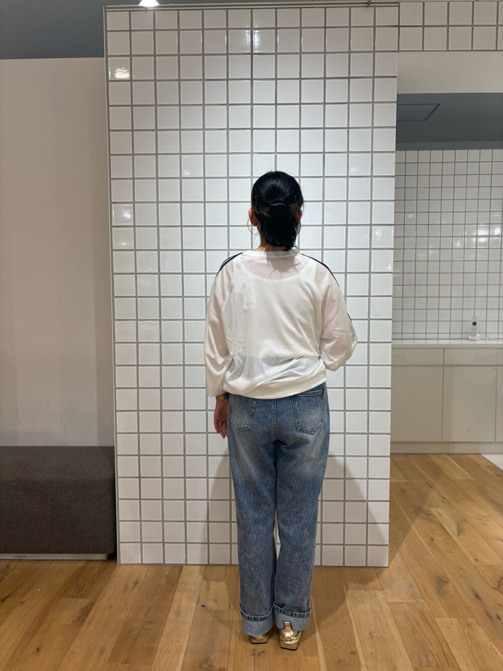 ブラック系のトートバッグ、ゴールド系のバレエシューズ、ホワイト系のタンクトップを着用したレディースの秋コーディネートの3枚目の写真