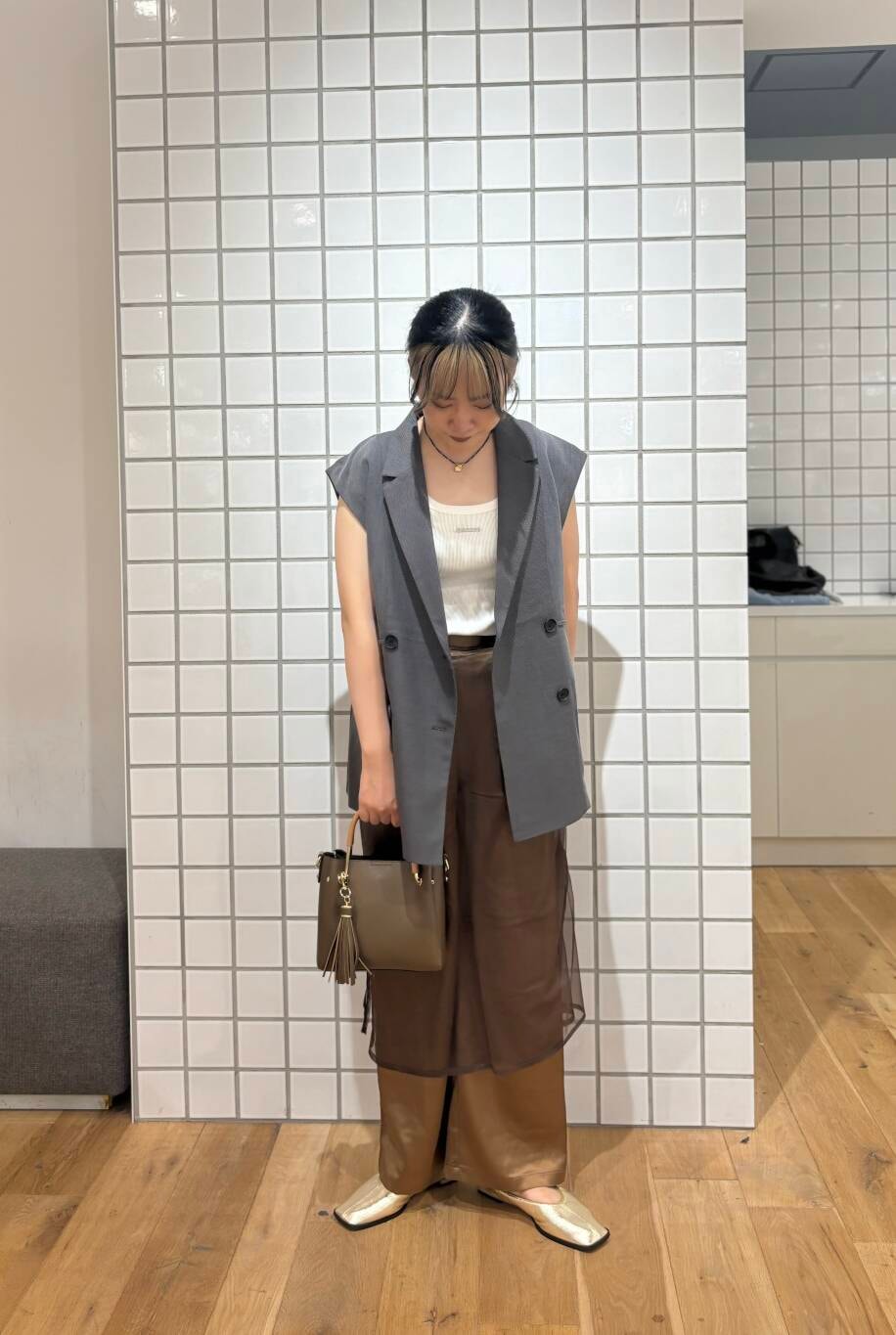 ゴールド系のバレエシューズ、ブラウン系のその他パンツ、グレー系のベストを着用したレディースの秋コーディネートの2枚目の写真