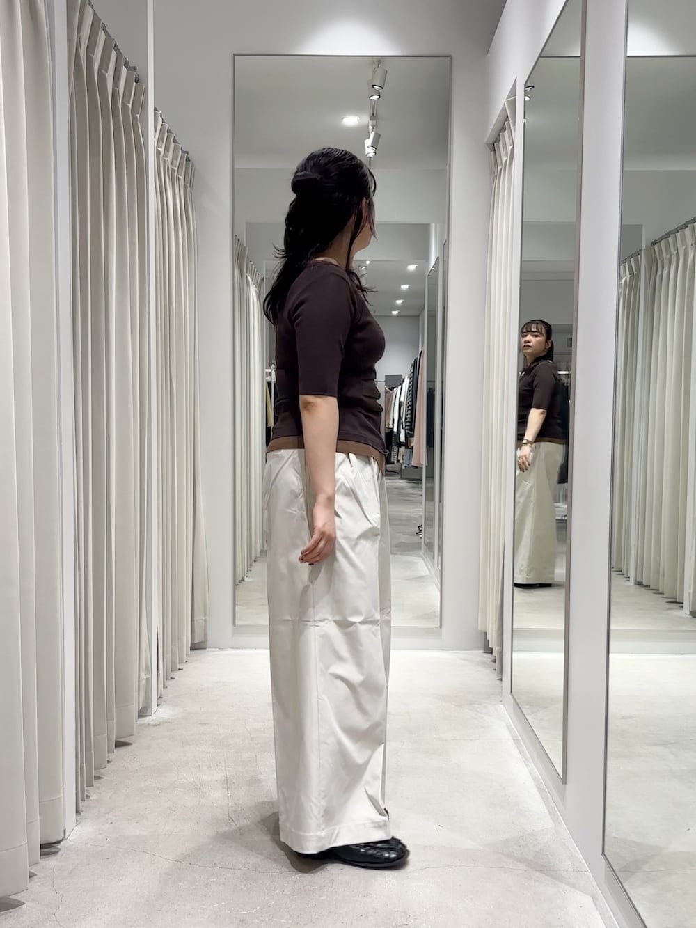 ブラウン系のニット/セーター、ホワイト系のチノパンツ、ブラック系のローファーを着用したレディースの春コーディネートの2枚目の写真