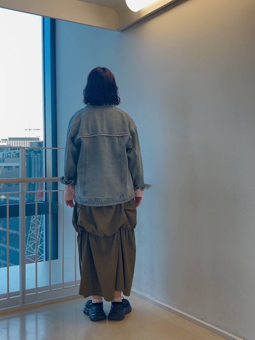 ブラック系のスニーカー、グリーン系のスカート、ピンク系のTシャツ/カットソーを着用したレディースの冬コーディネートの4枚目の写真