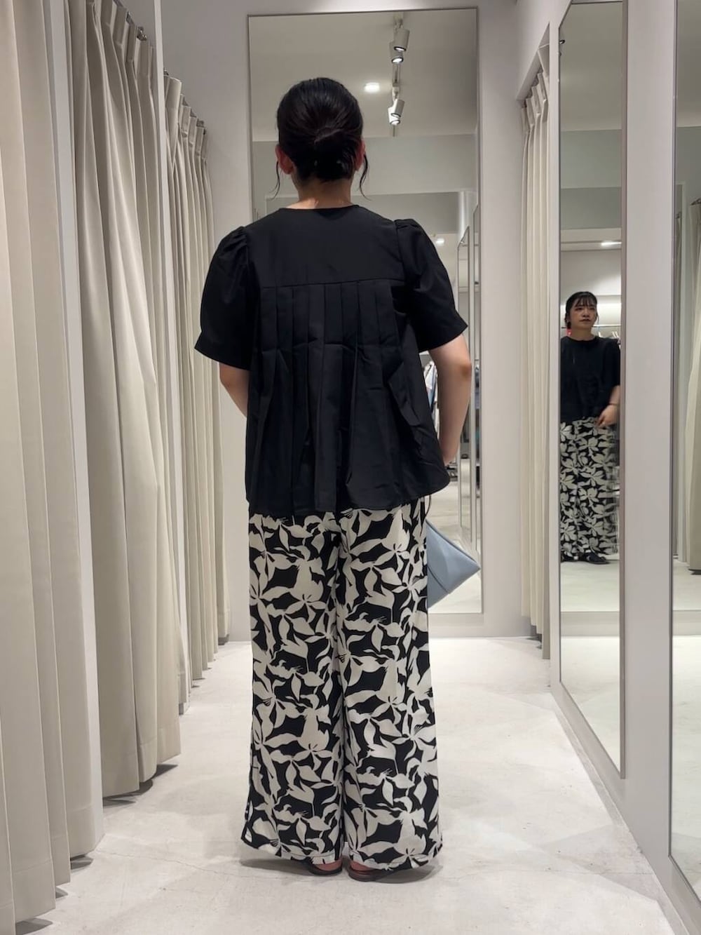 ブルー系のハンドバッグ、ブラック系のその他パンツ、ブラック系のシャツ/ブラウスを着用したレディースの夏コーディネートの4枚目の写真