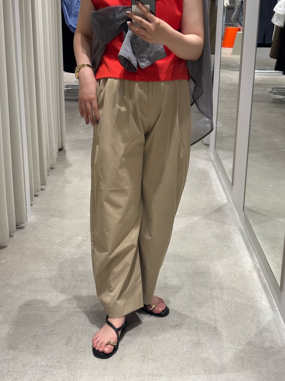 レッド系のタンクトップ、ベージュ系のその他パンツ、ブラック系のサンダルを着用したレディースの夏コーディネートの3枚目の写真