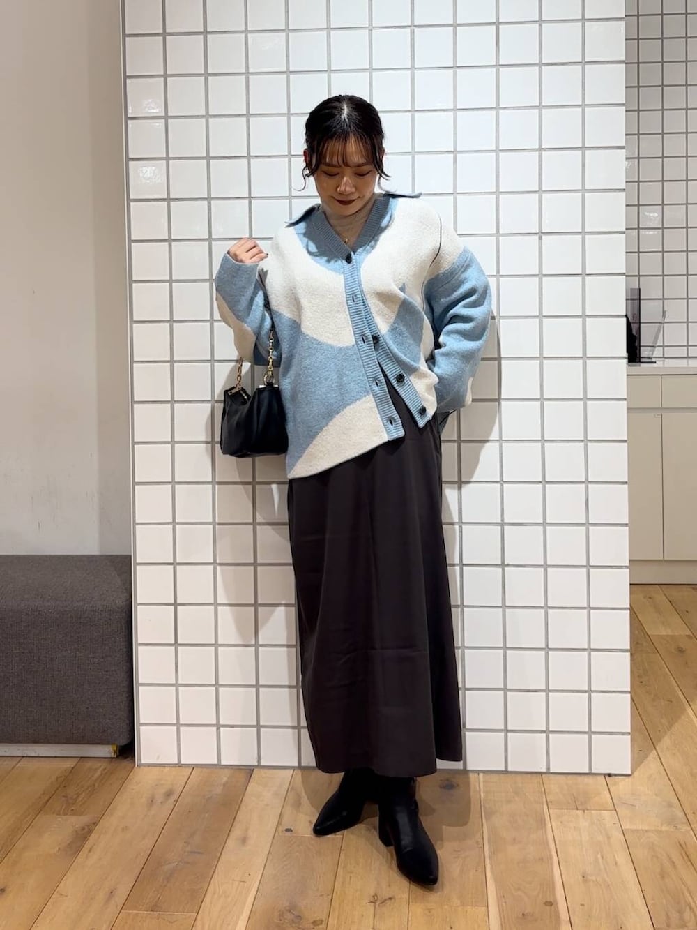 ベージュ系のTシャツ/カットソー、ブラック系のショルダーバッグ、ブラック系のブーツを着用したレディースの冬コーディネートの2枚目の写真