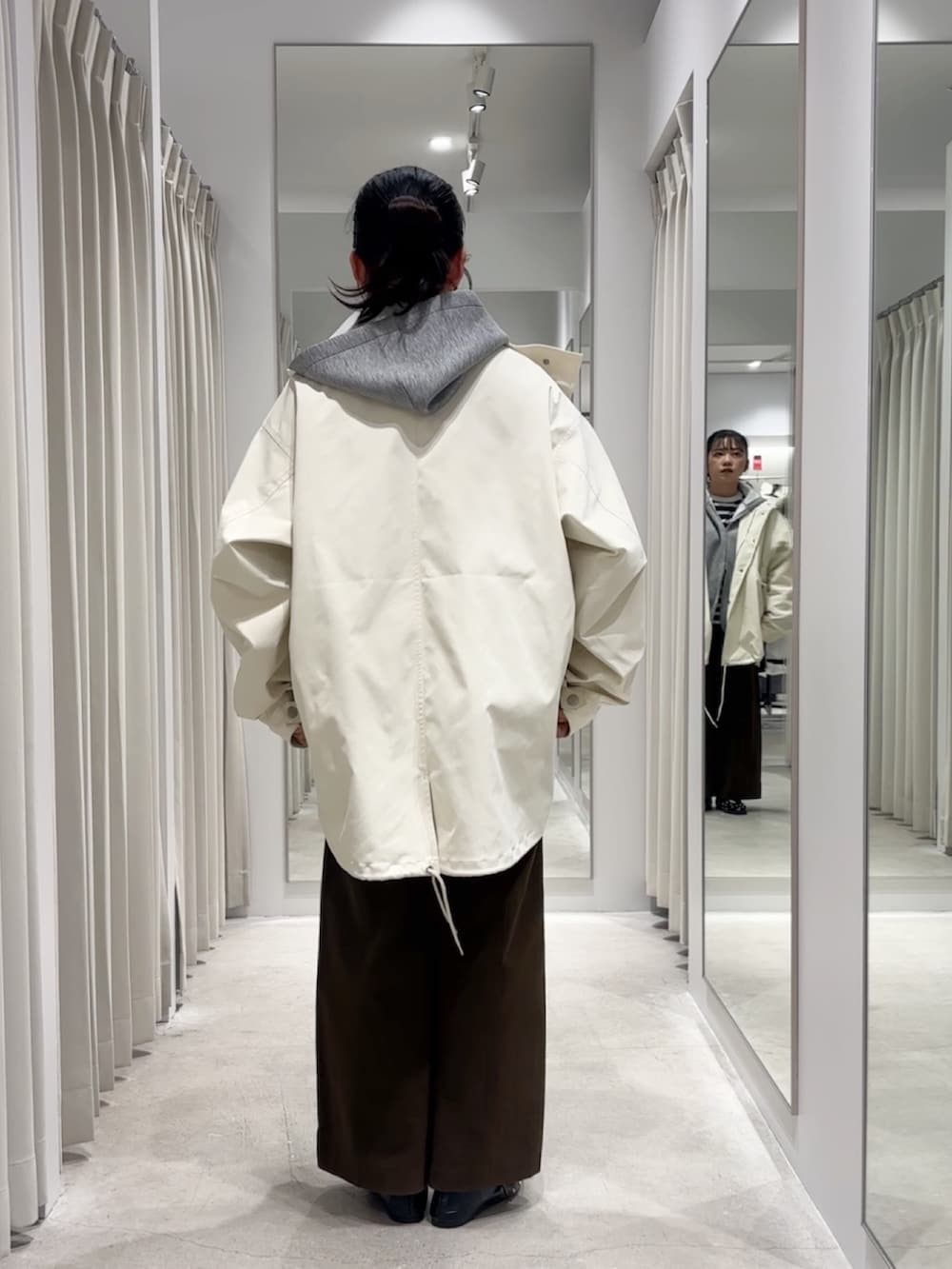 ホワイト系のミリタリージャケット、グレー系のパーカー、ブルー系のTシャツ/カットソーを着用したレディースの冬コーディネートの3枚目の写真