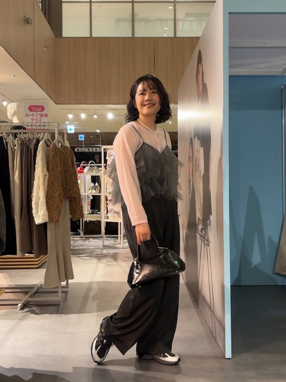 グレー系のその他パンツ、ブラック系のボストンバッグ、グレー系のスニーカーを着用したレディースの春コーディネートの4枚目の写真