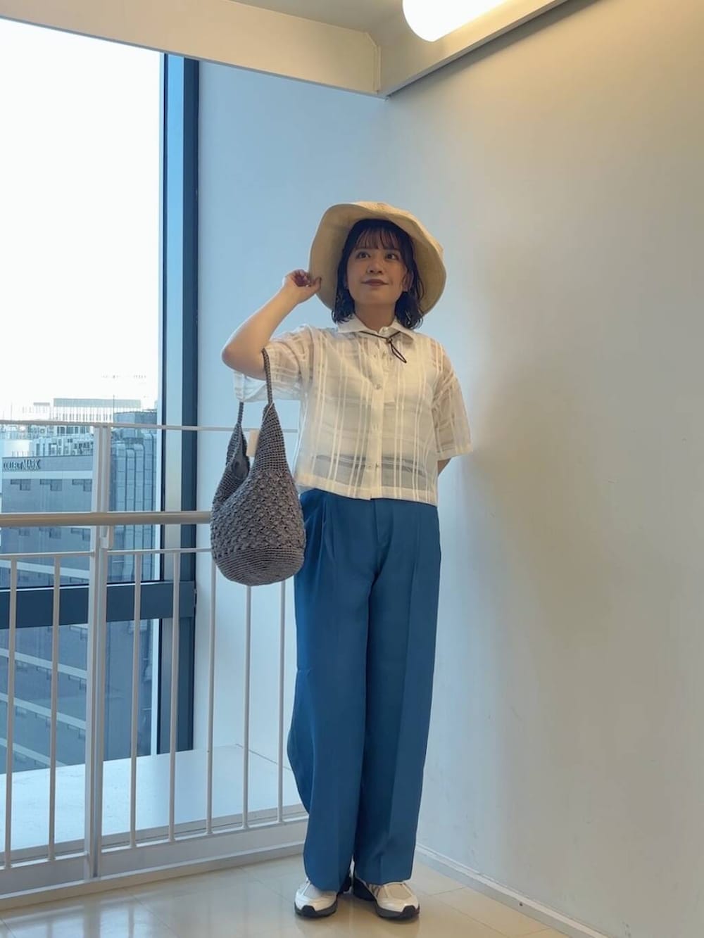 グレー系のハンドバッグ、ホワイト系のスニーカー、ブルー系のその他パンツを着用したレディースの春コーディネートの5枚目の写真