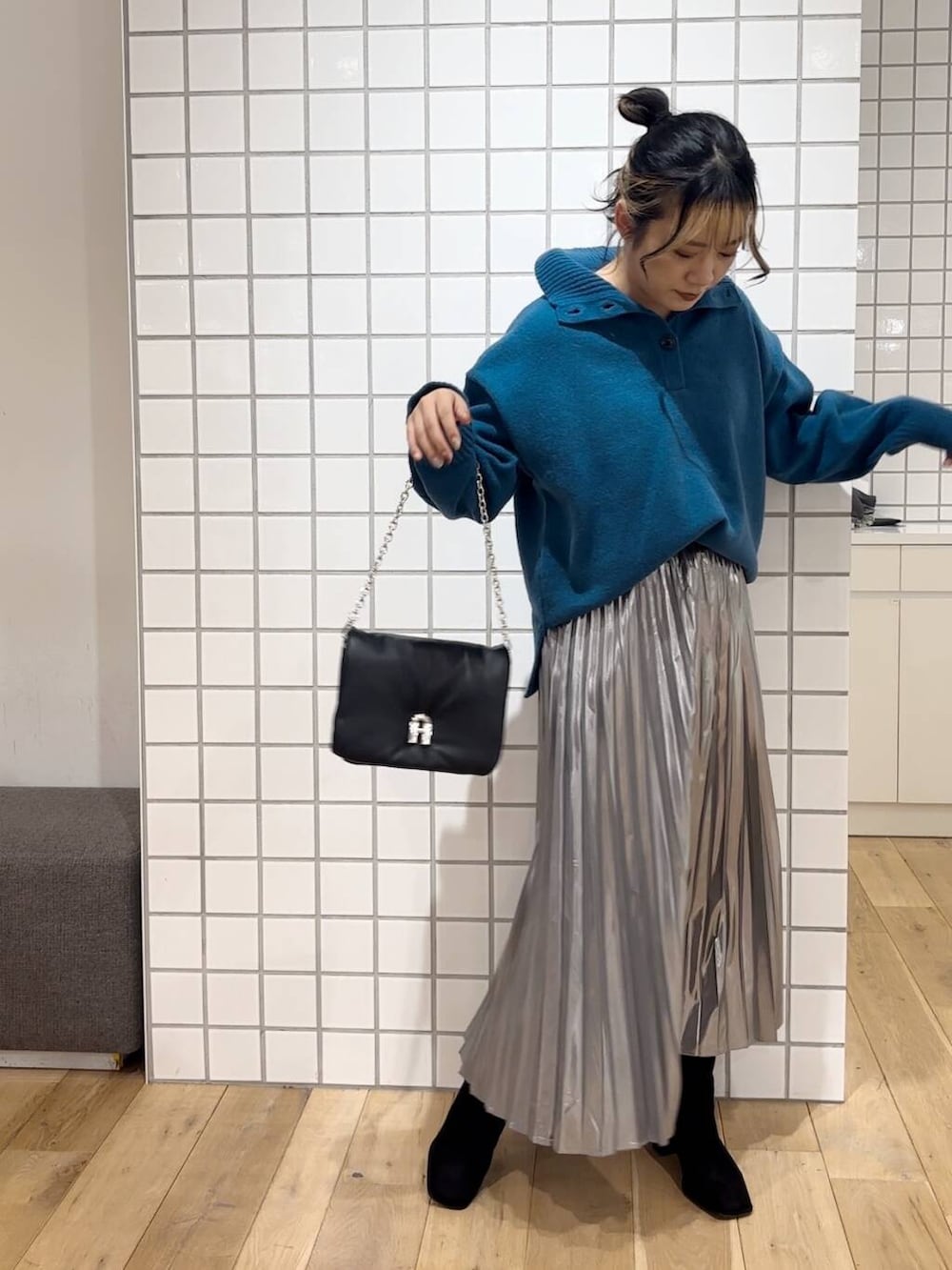 ブラック系のブーツ、ブラック系のショルダーバッグ、ブルー系のニット/セーターを着用したレディースの秋コーディネートの3枚目の写真